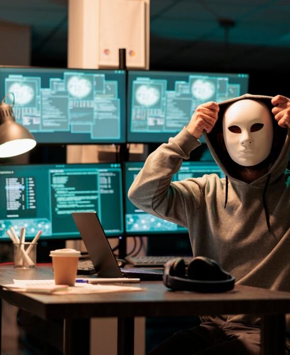 Scary masked hacker installing virus to hack system